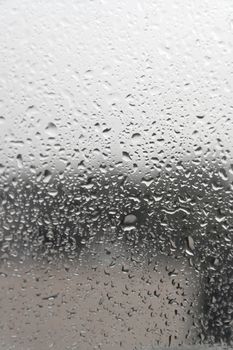 On a summer raining day. Drops of water on the window. Shallow DOF