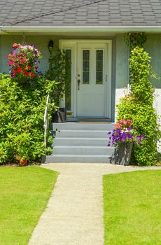 Entrance of family house with doorsteps and concrete pathway in front