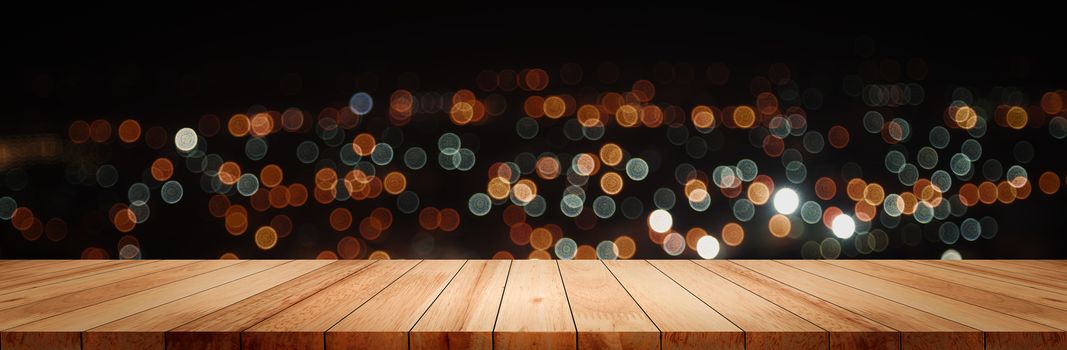 Panoramic empty clean wood counter table top on blur street night cafe background use for pub coffee shop montage dark scene, Blurry wide wooden texture shelf bar in luxury restaurant kitchen backdrop