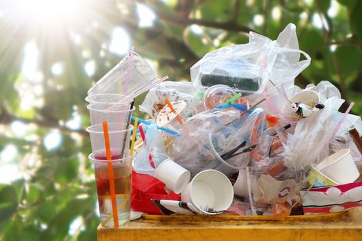 Waste plastic heap at bin, Trash full bin waste garbage, Plastic bag waste Lots of junk on nature tree sunshine background, Garbage many close-up