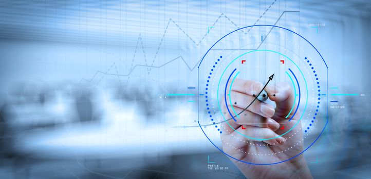 Concept of focus on target with digital diagram.close up of business hand working with new modern computer and business strategy as concept