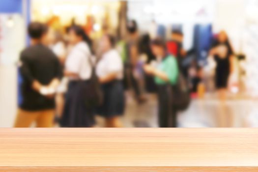 wood plank on blurred inside shopping mall and people walking shop, wood table board empty on clothing store fashion blur inside mall soft background