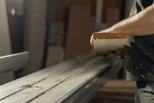 A man cuts wood on a circular saw in a joinery.