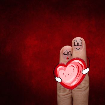 A happy finger couple in love with painted smiley and hold heart