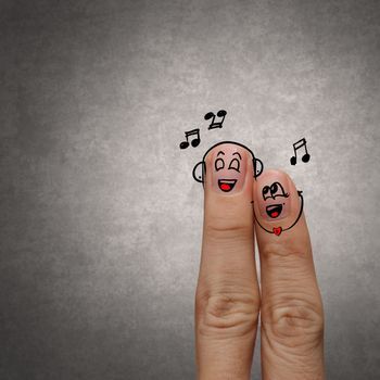 A happy finger couple in love with painted smiley and sing a song