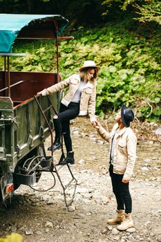 A beautiful girl and a handsome man in military truck. Lovestory. Military vehicle. Military fashion.Carpathian mountains.