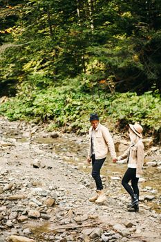 Young couple at the Carpathian - Happy tourists visiting mountains. Lovestory. Tourists in hats. Military fashion