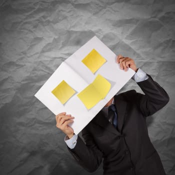 businessman hand show blank cover book and sticky note with crumpled recycle paper background 