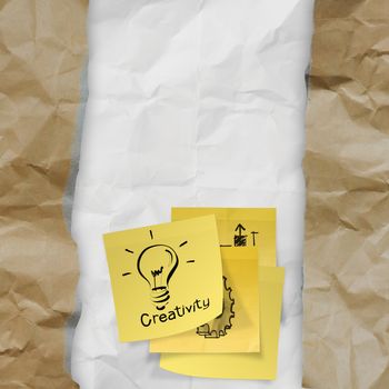 sticky note with  light bulb on crumpled paper as creative concept