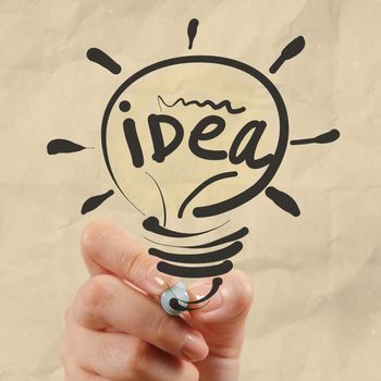 hand drawing light bulb with crumpled paper as creative concept