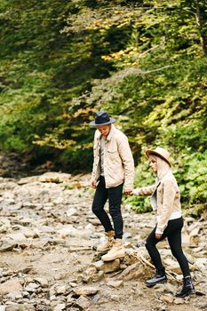 Young couple at the Carpathian - Happy tourists visiting mountains. Lovestory. Tourists in hats. Military fashion