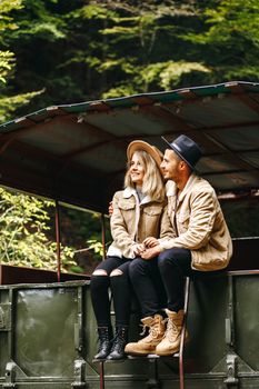 A beautiful girl and a handsome man in military truck. Lovestory. Military vehicle. Military fashion.Carpathian mountains.