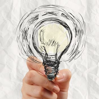 hand drawing light bulb with crumpled paper as creative concept