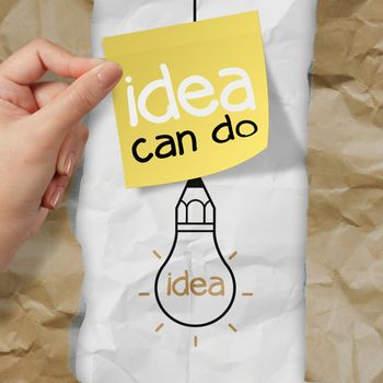 hand holding sticky note with idea can do word  light bulb on crumpled paper as creative concept