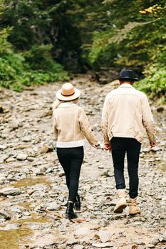 Young couple at the Carpathian - Happy tourists visiting mountains. Lovestory. Tourists in hats. Military fashion