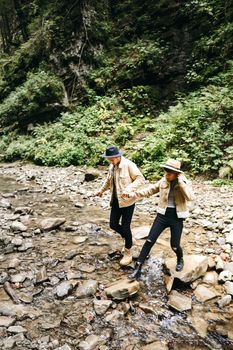 Young couple at the Carpathian - Happy tourists visiting mountains. Lovestory. Tourists in hats. Military fashion