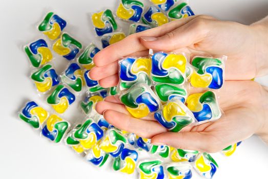 hand holds the Dishwasher Capsule. woman hand holding dishwasher detergent tablet