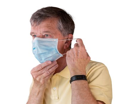 Senior caucasian man adjusting his face mask and looking very tense and concerned about coronavirus epidemic. Isolated against white