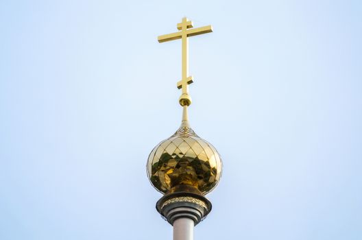 christian church with a dome and a cross without people against a blue sky