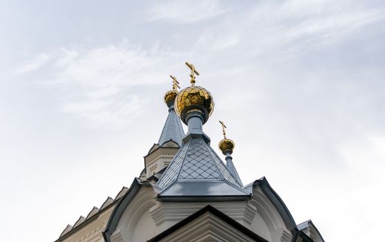 bottom view domes of christian church with crosses on blue sky background in Ukraine