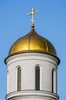 christian church with a dome and a cross without people against a blue sky