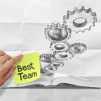 hand drawn gear cog best team with sticky note on crumpled paper as concept