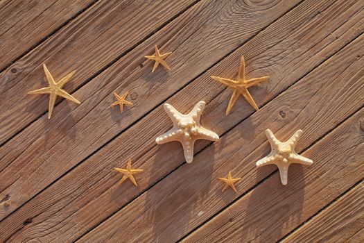 Starfish on a wooden pier poured over a wooden deck. Summer vacation concept. Holidays by the sea. High quality photo