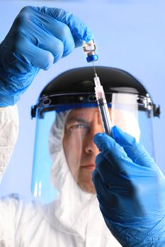 Worker in Biohazard Gear Drawing Vaccine Medication Wearing Gloves