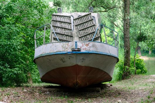 old boat on the river bank on green grass without people