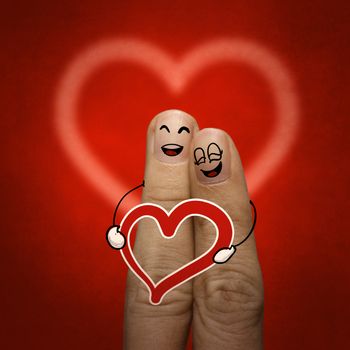 the happy finger couple in love with painted smiley and hold heart as vintage style