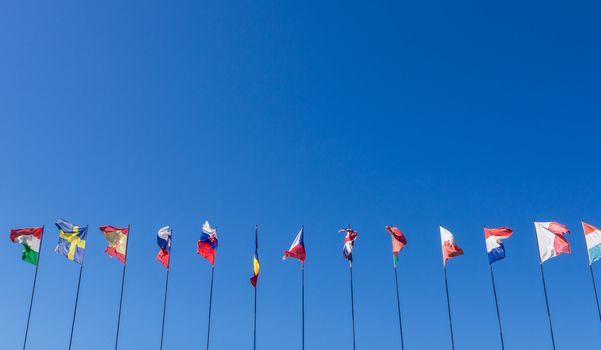 Row of national flags against blue sky