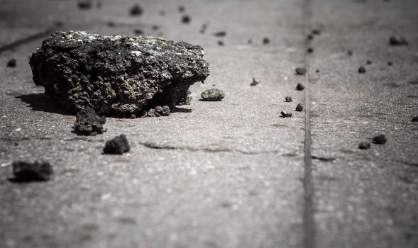 Cracked asphalt pieces background. Concept image. Defocused blurry background.