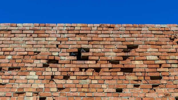 Old brick wall against bright sky