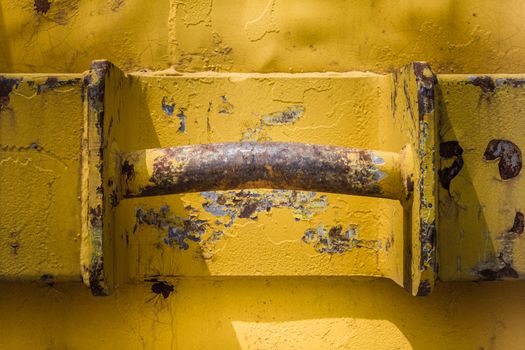 Big and old rusty handle of a rubble container