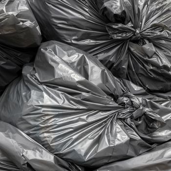 Pile of black garbage bags. Close-up for background.