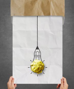 hand pulling light bulb crumpled paper out of recycle envelope as creative concept