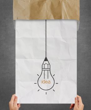 hand pulling light bulb crumpled paper out of recycle envelope as creative concept