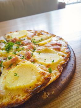 Pizza potato and ham on a wooden board