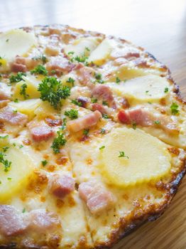 Pizza potato and ham on a wooden board