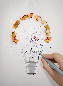 hand drawn light bulb with pencil saw dust on paper background as creative concept