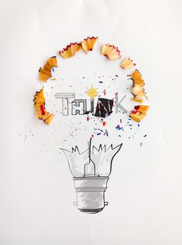 hand drawn light bulb word design THINK with pencil saw dust on paper background as creative concept