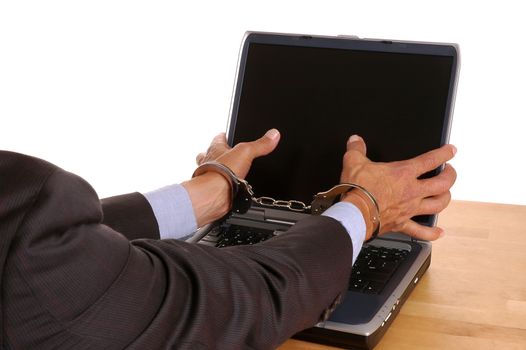 Businessmans handcuffed hands grabbing at laptop computer screen - isolated over white