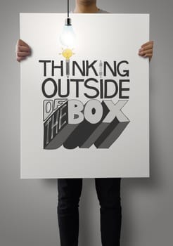 man showing poster of hand drawn  word THINKING OUTSIDE OF THE BOX with growing lightbulb as concept