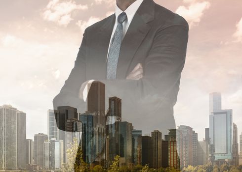 Double exposure of a businessman with his arms folded with city background.