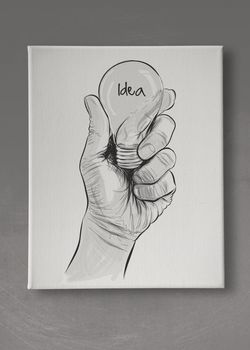 Hand drawn light bulb with IDEA word on canvas board as concept