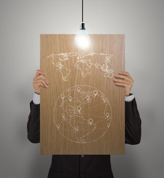 man showing poster of hand drawn world social network diagram on wooden board with growing lightbulb as concept 