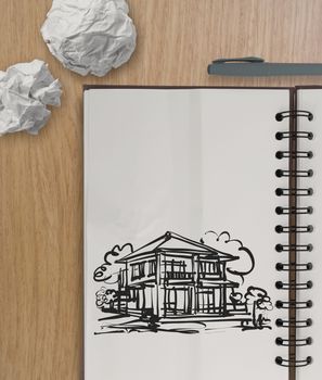 hand drawing house on wrinkled paper with wooden table as concept 