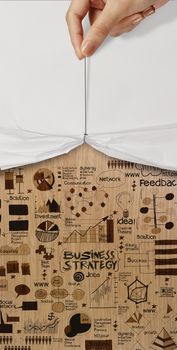 open crumpled paper showing hand drawn strategy business diagram on wood background as concept 