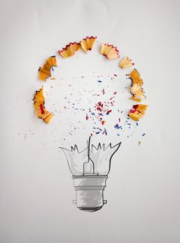 hand drawn light bulb with pencil saw dust on paper background as creative concept