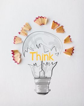 hand drawn light bulb word design THINK with pencil saw dust on paper background as creative concept